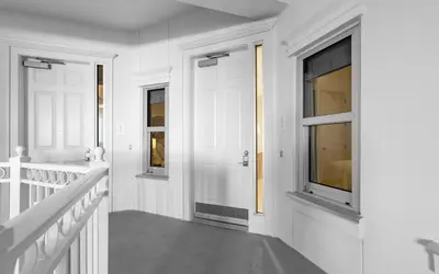 a white hallway with a door and windows at Sunset Oasis on 30A in Rosemary Beach