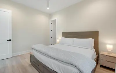 a bedroom with a large bed with white sheets and two lamps at Sunny Cove in Santa Rosa Beach