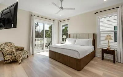 a bedroom with a bed and a tv and a chair at Sunny Cove in Santa Rosa Beach