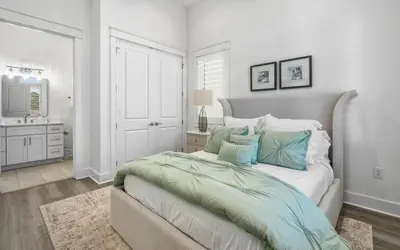 a bedroom with a large bed with blue pillows at Magnolia Way in Santa Rosa Beach