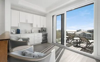 a kitchen and dining room with a large window at Magnolia Way in Santa Rosa Beach