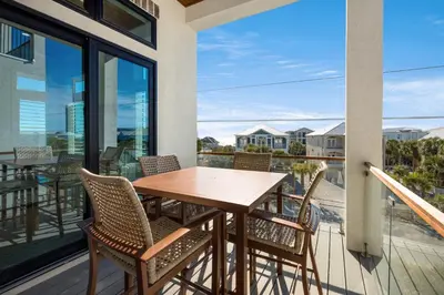 a balcony with a wooden table and chairs at Magnolia Way in Santa Rosa Beach