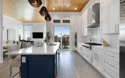 a kitchen with white cabinets and a blue island at Magnolia Way in Santa Rosa Beach