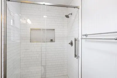 a white tiled shower with a glass door at Skinny Dip- Renovated Unit- Steps to the beach in Santa Rosa Beach