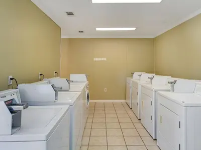 a row of white washing machines in a room at Skinny Dip- Renovated Unit- Steps to the beach in Santa Rosa Beach