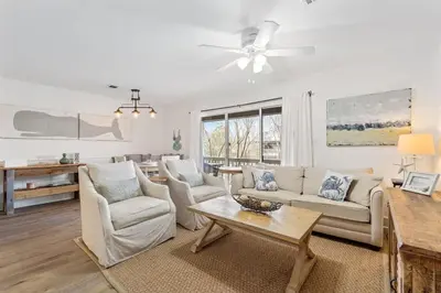 a living room with white furniture and a ceiling fan at Skinny Dip- Renovated Unit- Steps to the beach in Santa Rosa Beach