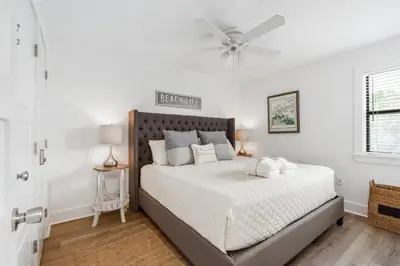 a bedroom with a large bed with a ceiling fan at Skinny Dip- Renovated Unit- Steps to the beach in Santa Rosa Beach