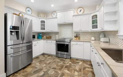 a kitchen with white cabinets and a stainless steel refrigerator at Bluesunshine in Santa Rosa Beach