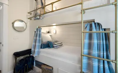 a bedroom with a bunk bed with blue curtains at Bluesunshine in Santa Rosa Beach