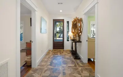 a hallway with white walls and a tile floor with a door at Bluesunshine in Santa Rosa Beach