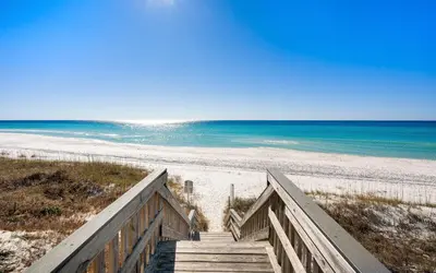 a staircase leading to a beach with the ocean at Bluesunshine in Santa Rosa Beach
