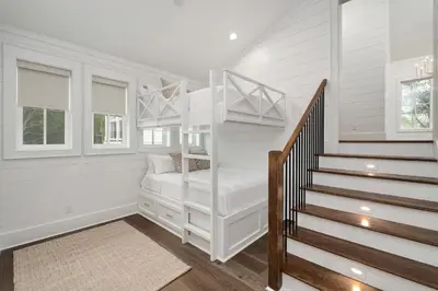 a white room with a bunk bed and stairs at Gulfside Hideaway in Santa Rosa Beach