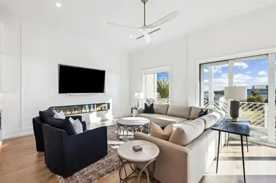 a living room with a couch and a tv at Gather at the Gulf in Inlet Beach
