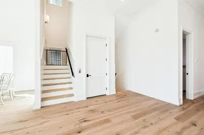 an empty living room with a staircase and white walls at Gather at the Gulf in Inlet Beach
