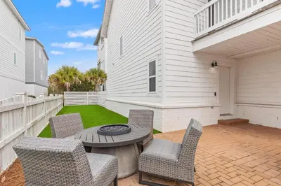 a patio with chairs and a table with a grill at 30A Beach House with Golf Cart - Whatcha Dune in Inlet Beach