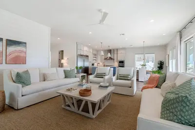 a living room with white couches and a table at Wine Down in Panama City Beach