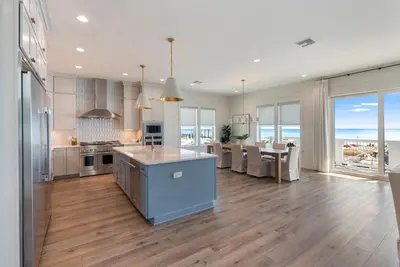 a kitchen and dining room with a view of the ocean at Wine Down in Panama City Beach