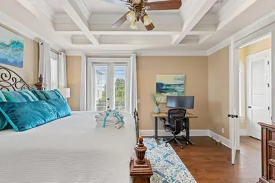 a bedroom with a bed with a ceiling fan and a desk at Poseidon's Grotto in Santa Rosa Beach