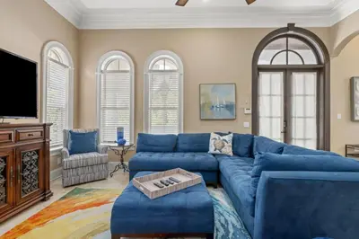 a living room with a blue couch and a tv at Poseidon's Grotto in Santa Rosa Beach
