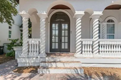 a white house with a door and a porch at Poseidon's Grotto in Santa Rosa Beach