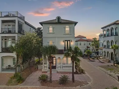 a house in the middle of a street with palm trees at Poseidon's Grotto in Santa Rosa Beach