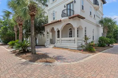 a large white house with palm trees in front of it at Poseidon's Grotto in Santa Rosa Beach