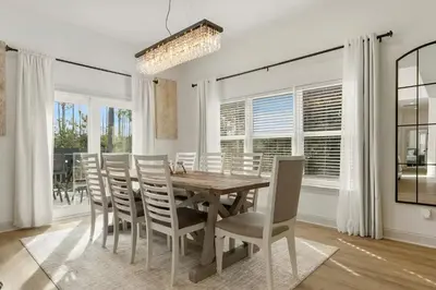 a dining room with a wooden table and chairs at Somerset by the Sea by Travel Life Vacations in Santa Rosa Beach