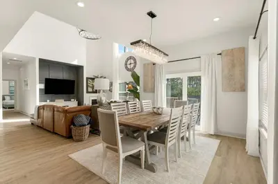 a dining room and living room with a table and chairs at Somerset by the Sea by Travel Life Vacations in Santa Rosa Beach