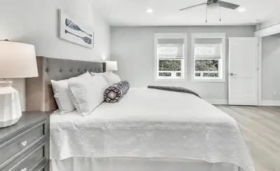 a white bedroom with a large white bed with pillows at Luxury by the Sea by Travel Life Vacations in Santa Rosa Beach