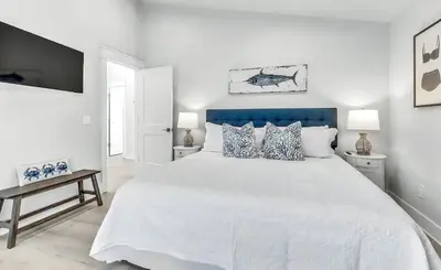 a white bedroom with a large white bed with pillows at Luxury by the Sea by Travel Life Vacations in Santa Rosa Beach