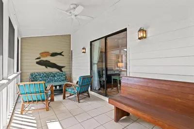 a porch with a bench and a table and chairs at Gulf Vista Condominiums in Seacrest
