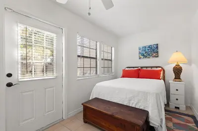 a bedroom with a bed with red pillows and a door at Gulf Vista Condominiums in Seacrest