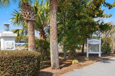 a sign for a resort with two palm trees at Gulf Vista Condominiums in Seacrest