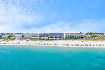 a beach with a group of beach chairs and buildings at Gulf Vista Condominiums in Seacrest