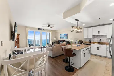 a kitchen and living room with a view of the ocean at Gulf-View Resort Condo with Pools & Beach Access by Dolce Vita Getaways in Panama City Beach
