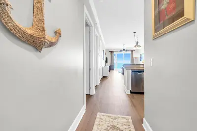 a hallway of a kitchen with white walls at Ocean Reef 2203 by Emerald Coast Retreats in Panama City Beach
