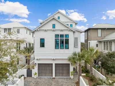 a white house with a garage at Katydid Beach Bungalow by 30A Escapes in Seagrove Beach