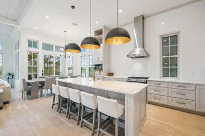 a kitchen with a large island with bar chairs at Katydid Beach Bungalow by 30A Escapes in Seagrove Beach