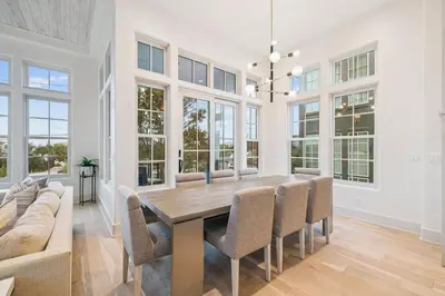 a dining room with a table and chairs and a couch at Katydid Beach Bungalow by 30A Escapes in Seagrove Beach