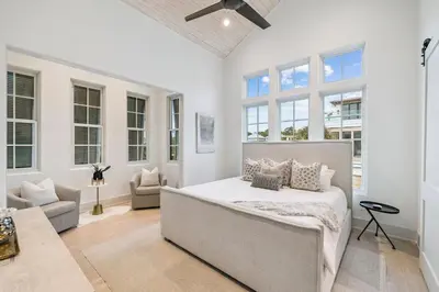 a bedroom with a bed and a couch and windows at Katydid Beach Bungalow by 30A Escapes in Seagrove Beach