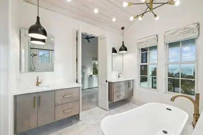 a bathroom with a tub and a sink and a mirror at Katydid Beach Bungalow by 30A Escapes in Seagrove Beach