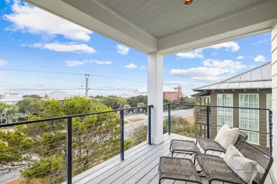 a porch with a couch and chairs on a balcony at Katydid Beach Bungalow by 30A Escapes in Seagrove Beach
