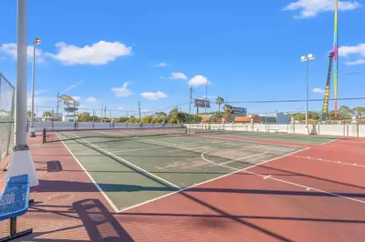 a tennis court with two people on it at The Summit 1421 - Wake to Gulf Views in Panama City Beach