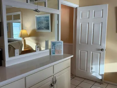 a bathroom with a mirror and a counter with a lamp at The Summit 830 - Ocean Front Condo in Panama City Beach
