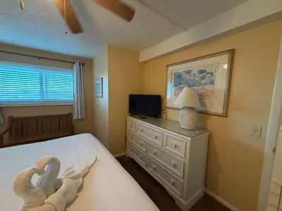 a bedroom with a bed with a dresser and a television at The Summit 830 - Ocean Front Condo in Panama City Beach