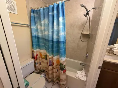 a bathroom with a shower curtain with a toilet at The Summit 830 - Ocean Front Condo in Panama City Beach