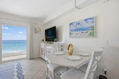a dining room with a table and a view of the ocean at The Summit 926 - One Bedroom Beachfront Condo in Panama City Beach