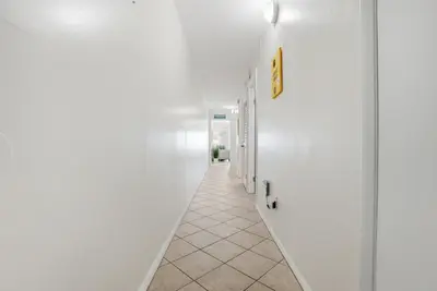 a hallway with white walls and a white floor at The Summit 926 - One Bedroom Beachfront Condo in Panama City Beach
