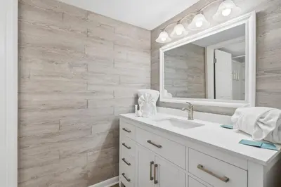 a bathroom with a white sink and a mirror at Dunes of Panama C104 - First Floor Gem in Panama City Beach