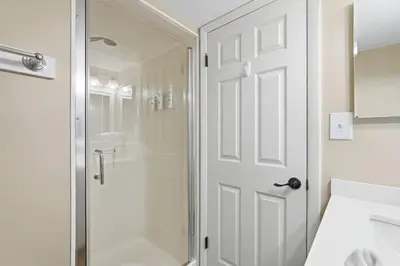 a bathroom with a shower and a glass door at Dunes of Panama C104 - First Floor Gem in Panama City Beach